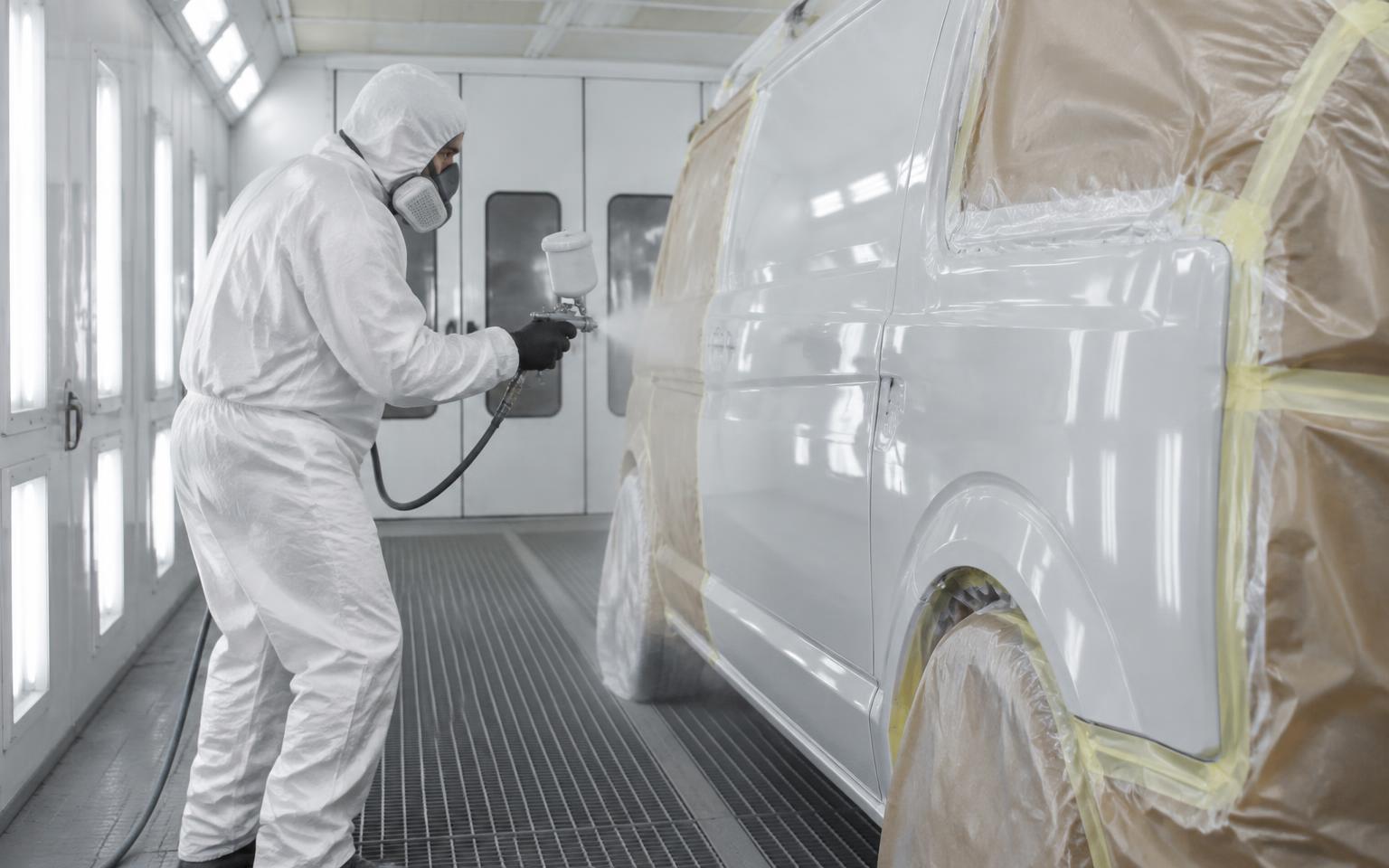 Vehicle being spray painted in a professional paint booth
