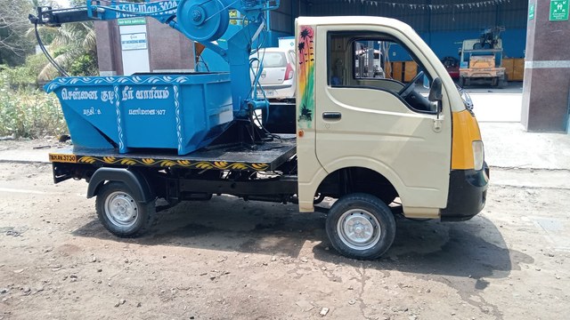 Compact municipal utility pickup vehicle at a city depot
