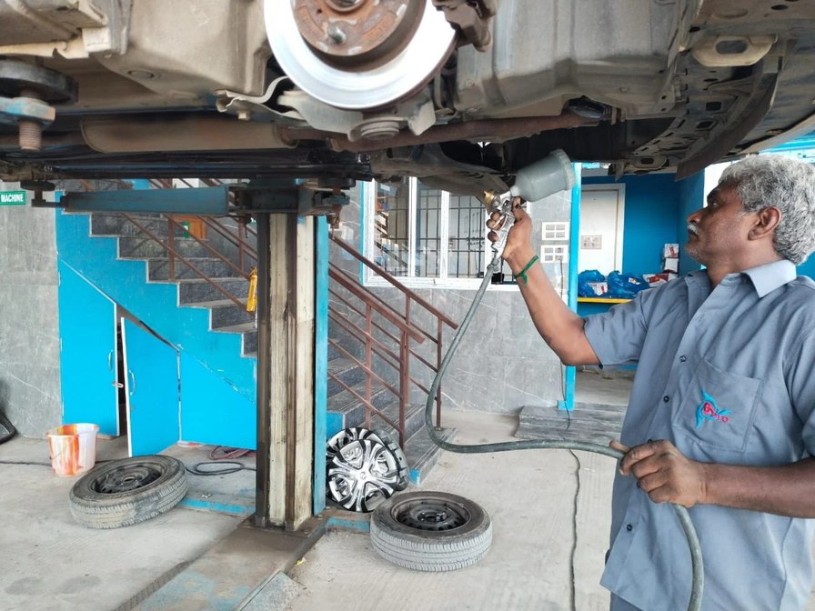 Underbody inspection and repair work on a vehicle at the workshop